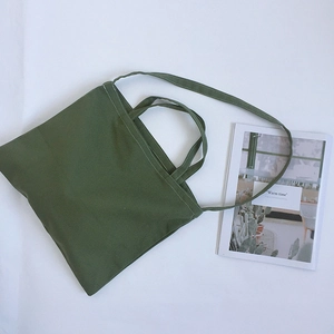 Olive green canvas tote bag with dual handles and shoulder strap on white background