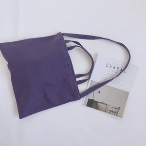 Detail view of purple canvas tote bag with dual handles on white background