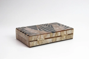 Detail of geometric acrylic clutch with marble texture and golden metal hinges