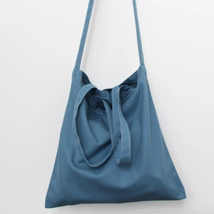 Detailed view of durable blue canvas fabric and stitching on a minimalist tote bag
