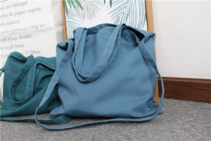 Detail of blue and dark cyan canvas tote bags with double straps and stitching details