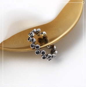 Macro detail of retro S925 sterling silver wave ring with black zircon flower inlay