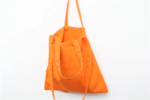Detail of vibrant orange canvas tote bag showing high-quality white stitching and thick fabric