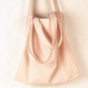 Detail view of pink canvas tote bag showing high-density cotton texture and handle stitching