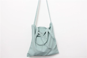 Detail view of mint green canvas tote bag with triple straps for shoulder and hand carry