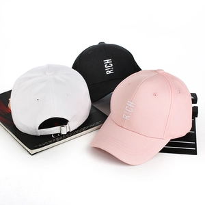 Detailed view of RICH embroidery on cotton baseball caps in white black and pink colors