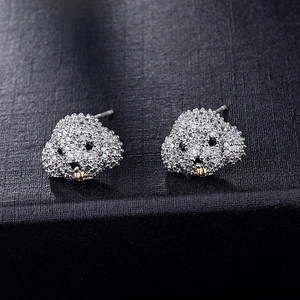 Macro detail of silver poodle earrings with white cubic zirconia and black gemstone eyes