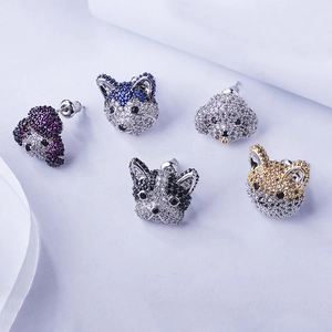 Macro detail of dog-shaped earrings set with colorful cubic zirconia and silver needles