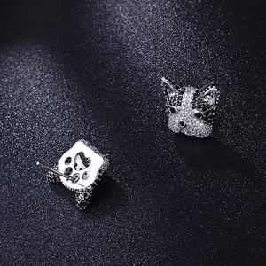 Macro shot of French Bulldog stud earrings with micro-paved zircons and heart cut-outs