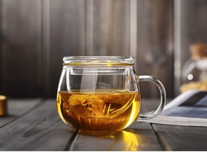 Macro detail of heat-resistant glass tea cup with removable infuser and lid for steeping