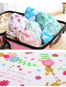 Detailed texture of printed cotton linen drawstring bags inside a pink travel suitcase