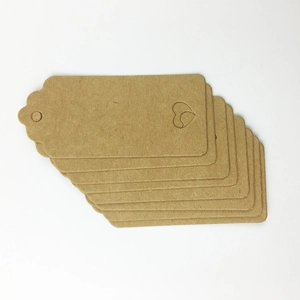 Close-up of brown kraft paper gift tags with scalloped edges and heart cut-outs