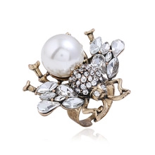 Macro shot of bee shaped ring with large pearl head and sparkling crystal wings