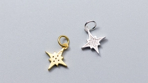 Détail macro de breloques étoiles en argent S925 avec incrustations de zircons brillants