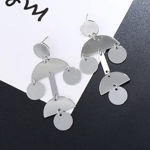 Detail of silver drop earrings with layered geometric disks and polished mirror finish