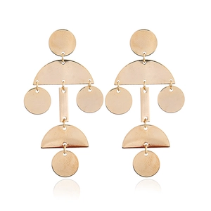 Detailed view of golden geometric teardrop earrings with smooth metallic finish on white