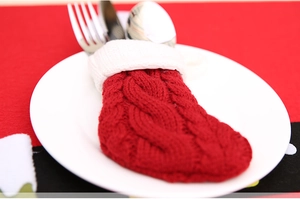 Gros plan d'un porte-couverts de Noël tricoté rouge et blanc sur une assiette