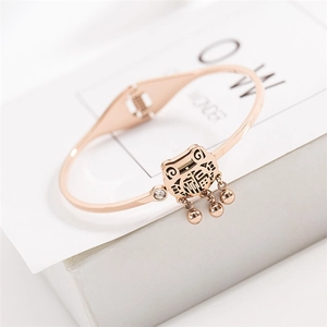 Détail d'un jonc en or rose avec pendentif Fu et incrustation de zircon blanc