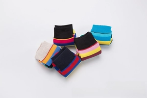 Flat lay detail of five pairs of colorful rainbow striped cotton socks in various colors