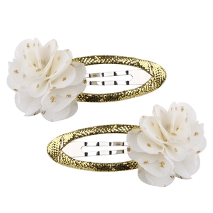 Dettaglio di fermagli per capelli dorati con fiori in tessuto bianco e glitter oro