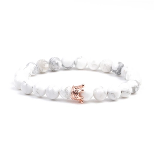 Détail des perles en pierre blanche de 8mm avec une couronne en or rose sur le bracelet