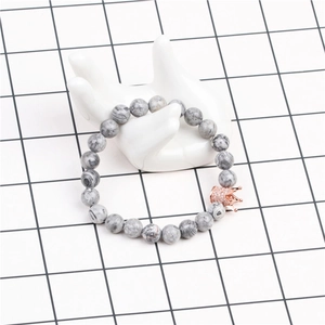Détail de perles en pierre de pin blanc 8mm et breloque couronne or rose avec zircons