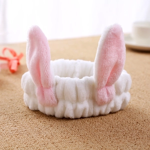 Detailed view of soft plush white rabbit ear headband with pink inner lining accents