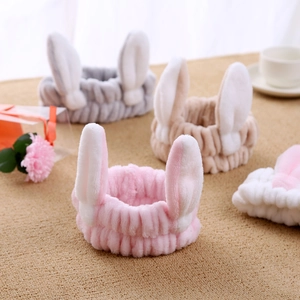 Detailed view of plush cat ear headbands in pink, grey, khaki and white soft fabric