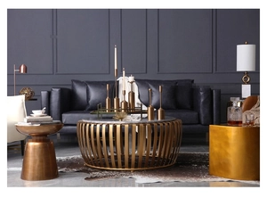 Primer plano de candelabros de metal dorado y mesa de centro de mármol en entorno de lujo