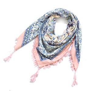 Close-up of pink bohemian floral scarf with blue patterns and knotted tassel details