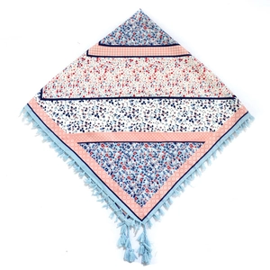Detail of bohemian floral print scarf featuring patchwork patterns and blue tassel edges
