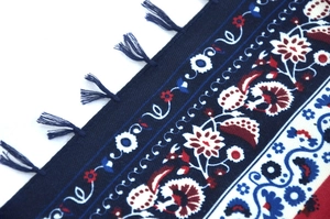 Macro view of Bohemian jacquard square scarf with ethnic floral patterns and tassel details