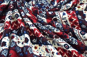 Detailed close-up of Bohemian ethnic jacquard fabric pattern with fringe and tassels