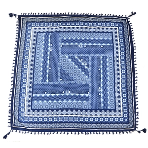 Detail of blue and white bohemian scarf with geometric jacquard patterns and fringed edges