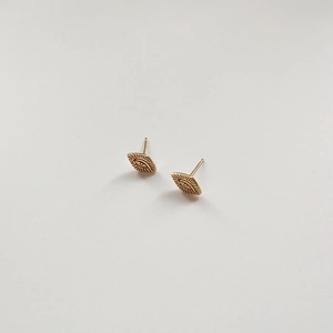 Macro shot of minimalist gold eye-shaped stud earrings in polished 925 sterling silver