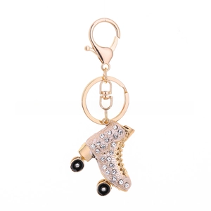Close-up of pink rhinestone roller skate keychain with gold lobster clasp and white background