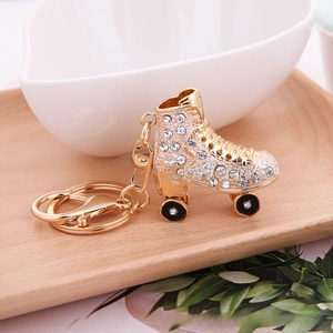 Detailed macro view of gold-plated roller skate keychain encrusted with crystal rhinestones