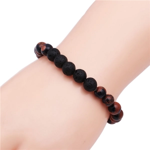 Mens 8mm black lava and brown sandstone beaded stretch bracelet on a model wrist