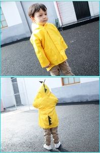 Detail view of yellow children's dinosaur raincoat with 3D fins and button closure