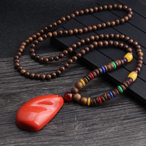 Ethnic style necklace with dark brown wood beads and a red stone pendant for men and women