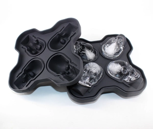 Detail of black silicone skull ice mold showing four transparent skull-shaped ice cubes