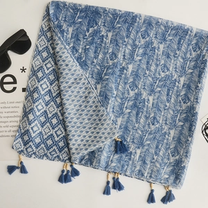 Detail of bohemian cotton linen scarf with blue tassels, wood beads and feather patterns