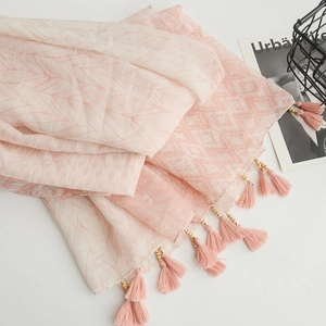 Close-up of pink Bohemian scarf featuring delicate tassels and golden bead accents