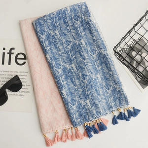Detail of bohemian cotton linen scarf with blue feather print, wood beads and tassels