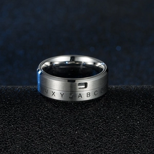 Creative rotating silver stainless steel ring with engraved letters on dark textured surface