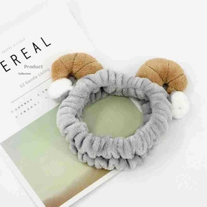 Close-up of grey plush headband with decorative horns and soft fleece texture