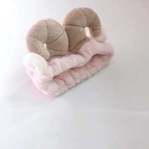 Close-up of pink plush headband with cute brown ram horns and soft white ears