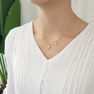 Detailed close-up of 925 silver golden lock and key pendant necklace on female neck