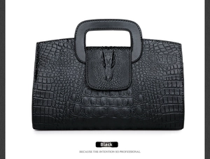 Detail view of crocodile pattern handbag with wolf head relief buckle and handle