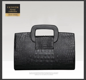 Detail view of the sleek back design and textured crocodile pattern on this black handbag